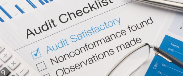 Audit checklist on a desk, with tick against audit satisfactory